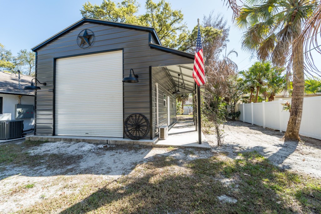 Detached metal garage and workshop with roll-up door at Vero Beach home, listing photography