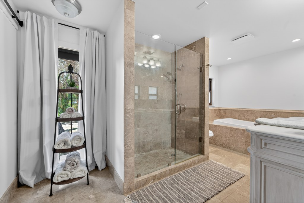 Travertine bathroom with glass walk-in shower and soaking tub, Vero Beach real estate photography