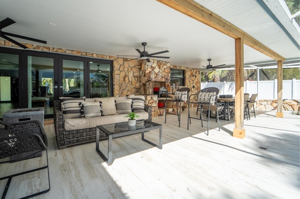 Covered lanai outdoor living room with stone fireplace, Vero Beach pool home photography