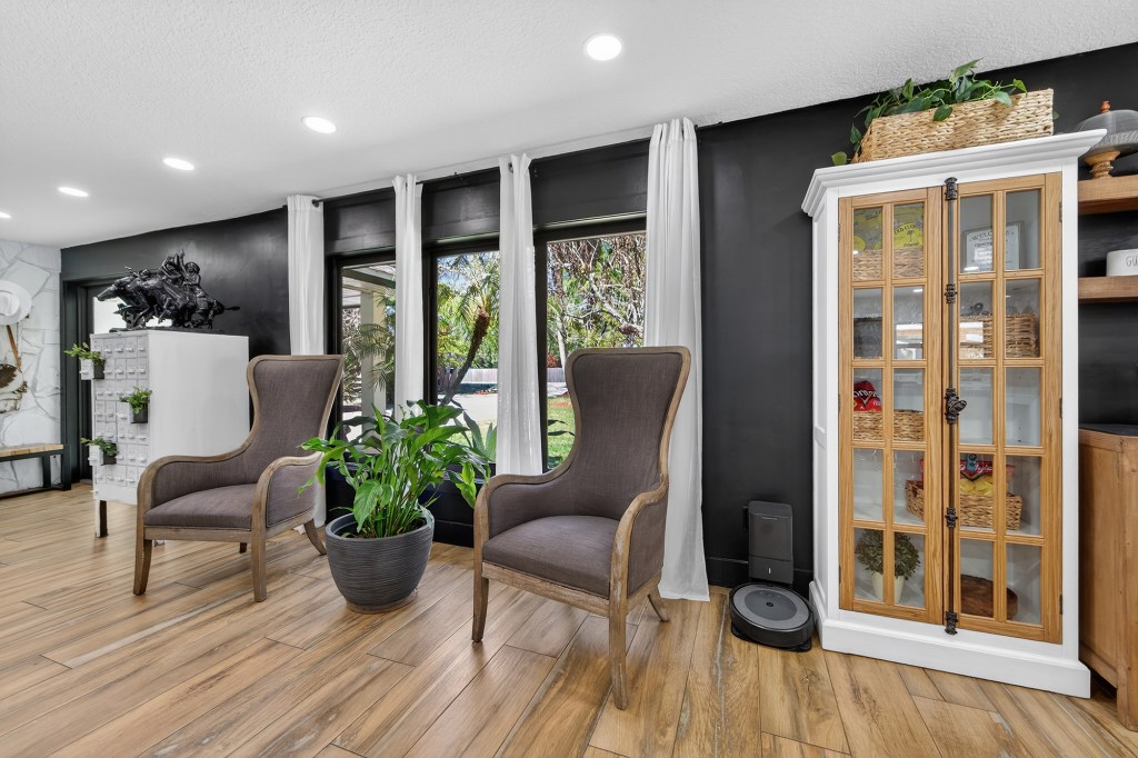 Sitting room with black accent wall in renovated Vero Beach home, listing photos