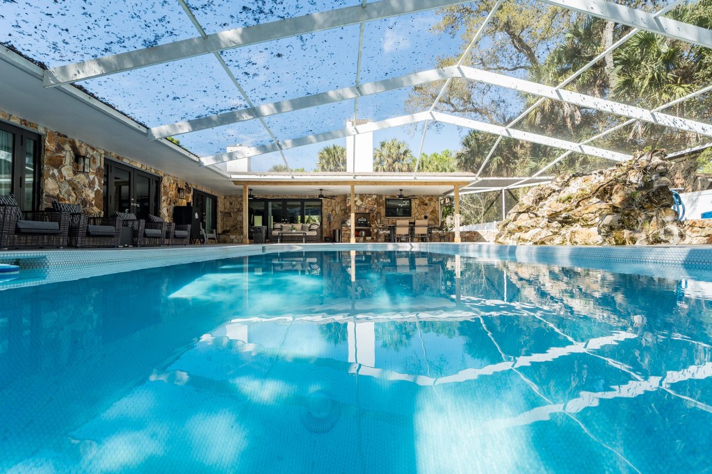 Screened pool with rock waterfall at renovated Vero Beach pool home, real estate photography